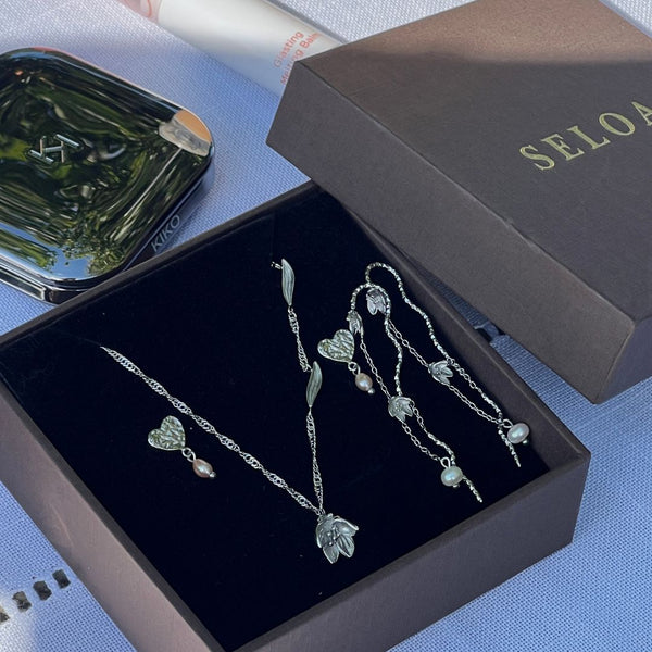 Elegant Lily Set fra Seloa – feminint smykkesæt med liljeinspireret design, vandfaste og slidstærke smykker til hverdagsbrug.