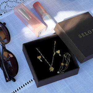 Golden Lily Set fra Seloa – feminint smykkesæt med liljeinspireret design, vandfaste og slidstærke smykker til hverdagsbrug.