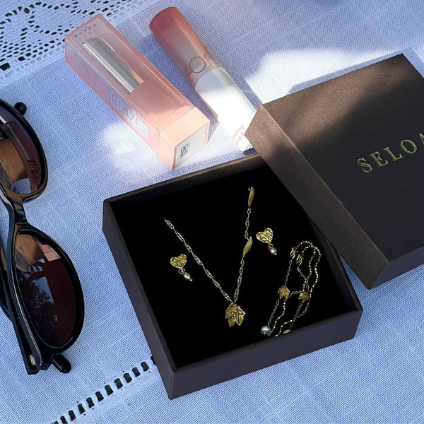 Golden Lily Set fra Seloa – feminint smykkesæt med liljeinspireret design, vandfaste og slidstærke smykker til hverdagsbrug.