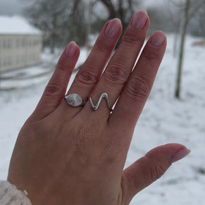 Model bærer Wave Ring i sølvfarvet rustfrit stål.