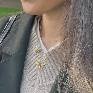 Guldsmede Aura Halskæde vist i bevægelse med fokus på det elegante design og den gyldne finish.